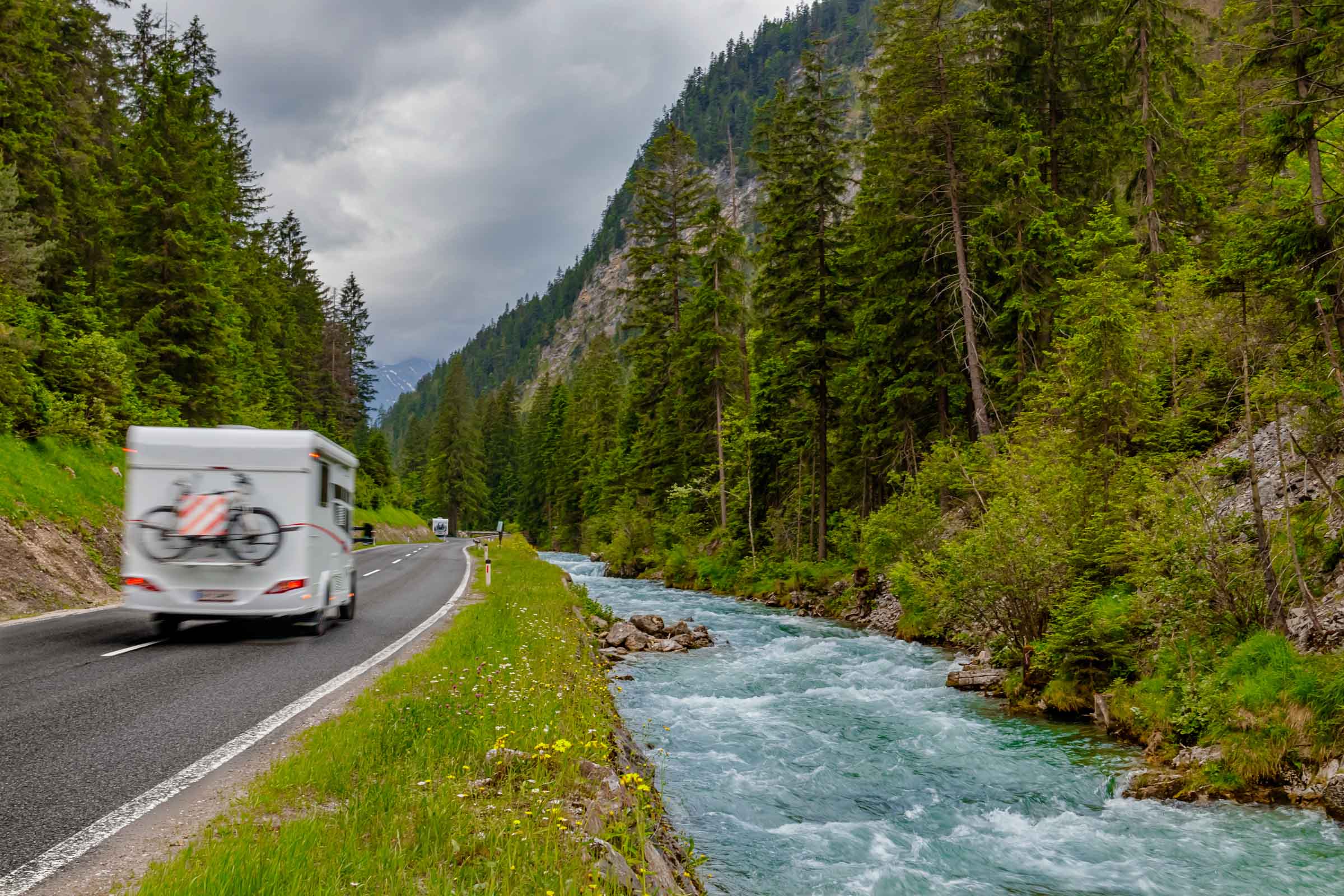 Main Home Page Photo With Camper Surrounded by Mountains
